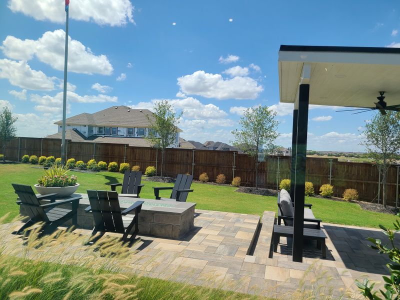 A spacious backyard with a modern seating area and lush landscaping in Ten Mile Creek 55s by American Legend Homes (Celina, TX). A spacious backyard with a modern seating area and lush landscaping in Ten Mile Creek 55s by American Legend Homes (Celina, TX).