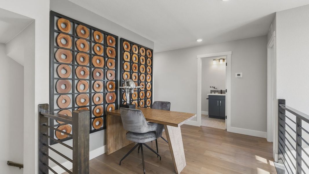 Elegant office boasts artistic wall installation, rustic wooden desk, and sleek railing in Dillon Pointe. Elegant office boasts artistic wall installation, rustic wooden desk, and sleek railing in Dillon Pointe.