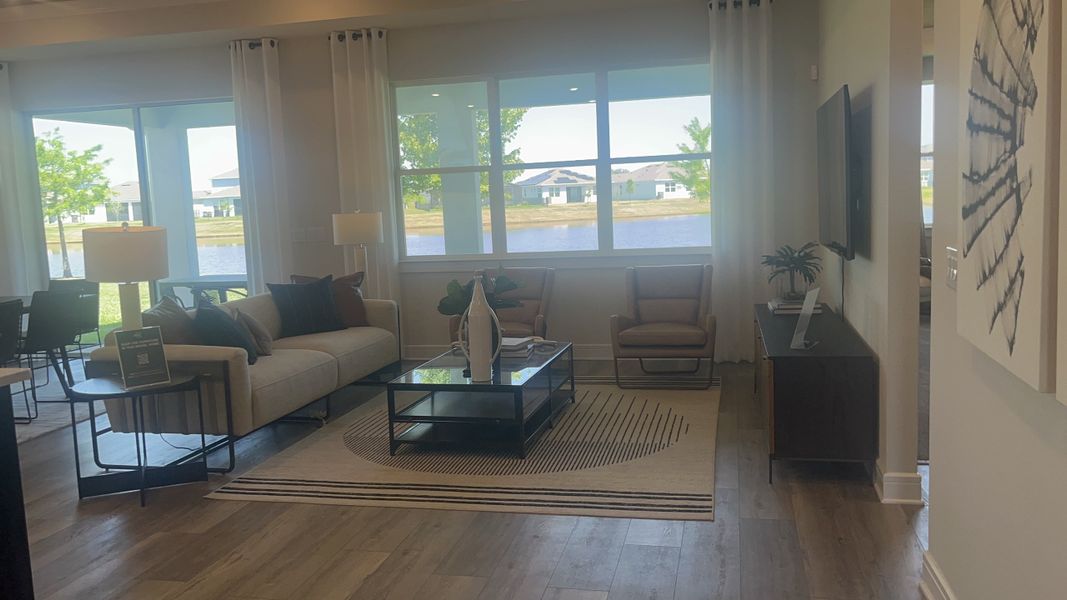 A cozy living room with a modern sofa, large windows offering scenic views, and stylish decor.