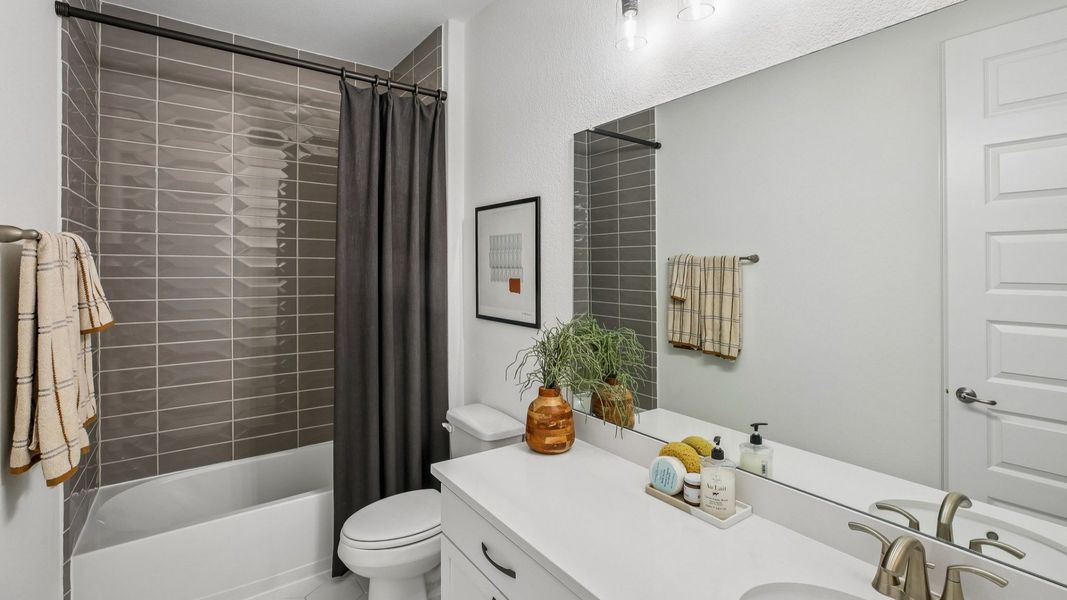 Luxurious bathroom features sleek white vanity, stylish gray tile, and premium fixtures in Cypress Green. Luxurious bathroom features sleek white vanity, stylish gray tile, and premium fixtures in Cypress Green.