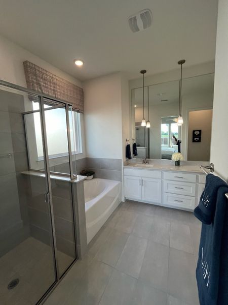 A modern bathroom with a glass shower, soaking tub, dual vanity, and sleek lighting fixtures. A modern bathroom with a glass shower, soaking tub, dual vanity, and sleek lighting fixtures.