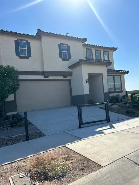 A modern beige stucco home with dark trim in Ventana de Estrellas Enclaves by KB Home (Goodyear, AZ).