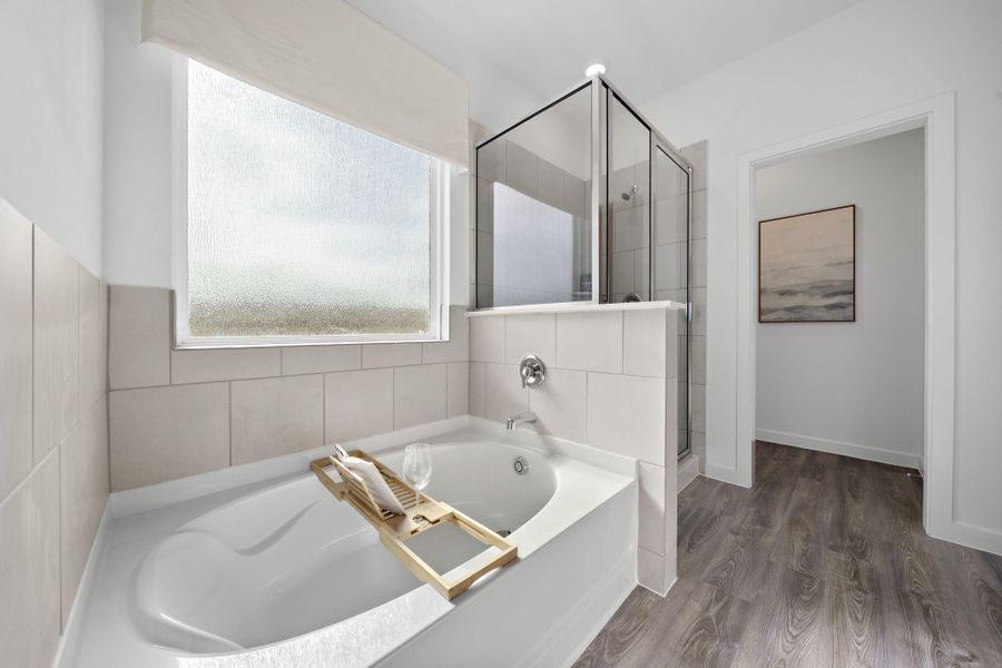 A bathroom with a tub sink and a mirror.