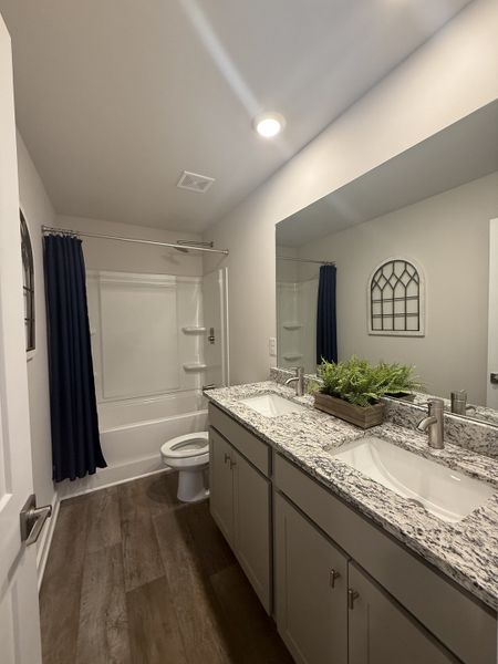 A modern bathroom featuring a granite countertop, double sinks, and elegant dark curtains for a sleek, sophisticated look. A modern bathroom featuring a granite countertop, double sinks, and elegant dark curtains for a sleek, sophisticated look.