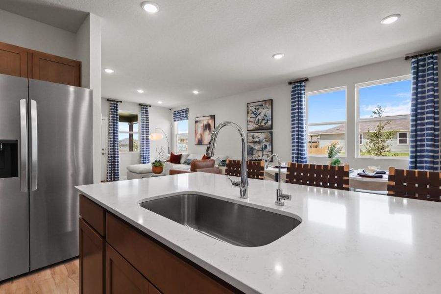 A kitchen with a sink and a refrigerator.