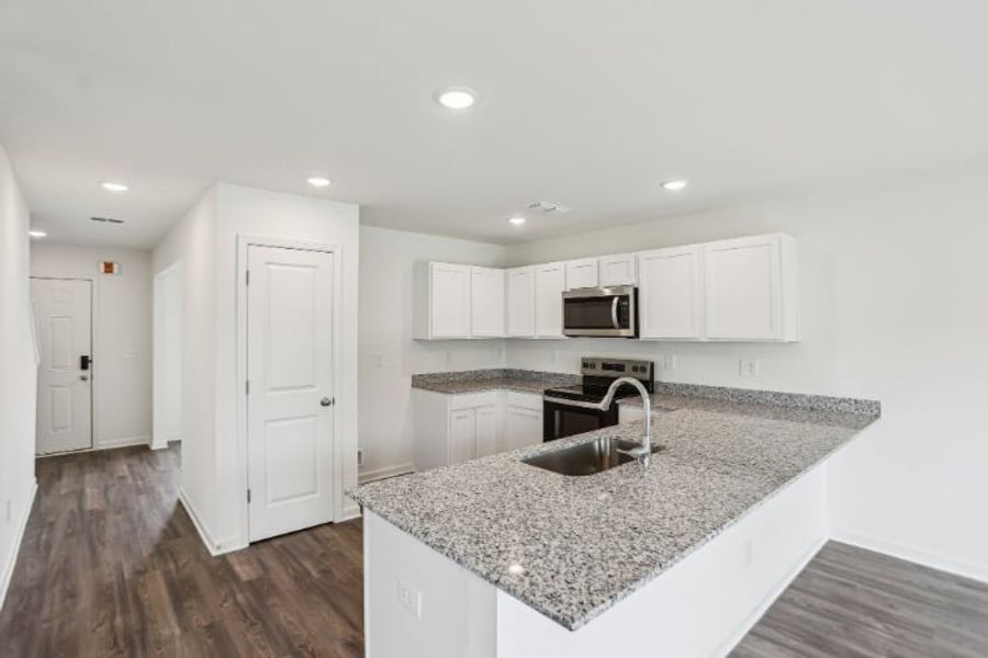 A kitchen with white cabinets.