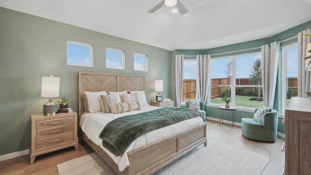 Luxurious bedroom features vaulted ceiling, expansive windows, and chic wood finishes in Wildflower Ranch. Luxurious bedroom features vaulted ceiling, expansive windows, and chic wood finishes in Wildflower Ranch.