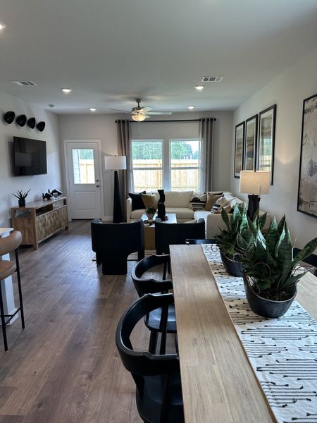 A modern living space featuring wood flooring, stylish seating, and abundant natural light with sleek decor elements.