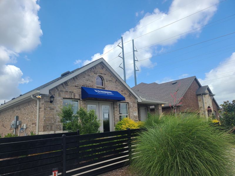 Charming brick home with blue awning and lush landscaping in Elevon by D.R. Horton (Lavon, TX). Charming brick home with blue awning and lush landscaping in Elevon by D.R. Horton (Lavon, TX).