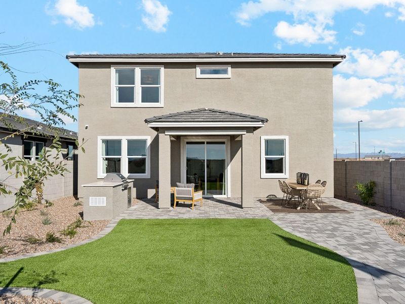 A house with a lawn and chairs.