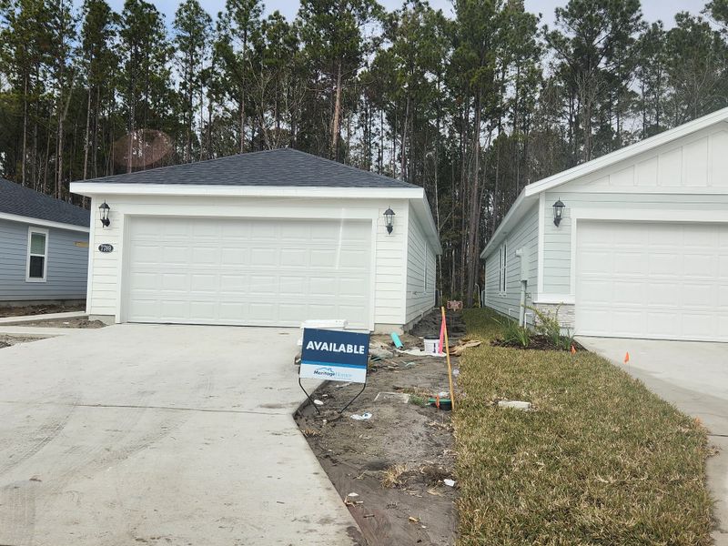 A modern white garage-front home with a neat driveway in Kings Preserve by Meritage Homes (Jacksonville, FL).