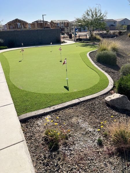 A serene putting green surrounded by a landscaped area in The Ridge Collection at Superstition Vista by Century Communities (Apache Junction, AZ). A serene putting green surrounded by a landscaped area in The Ridge Collection at Superstition Vista by Century Communities (Apache Junction, AZ).