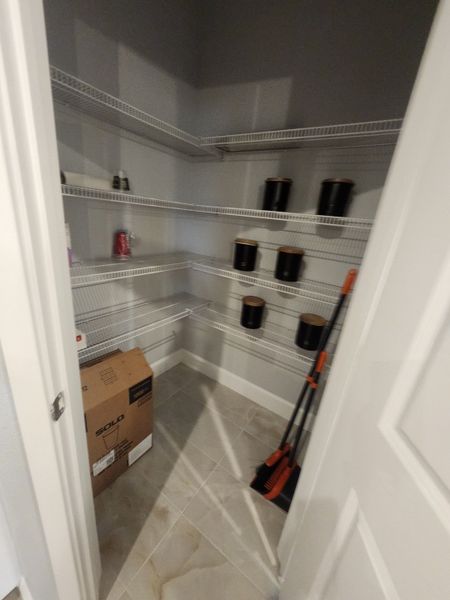 A spacious pantry with ample wire shelving and tiled floor, perfect for organized storage solutions.