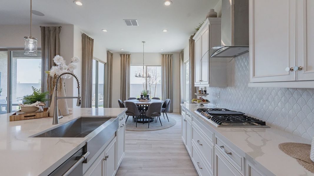 Elegant white cabinetry and high-end steel fixtures in Windrose's luxurious kitchen design.