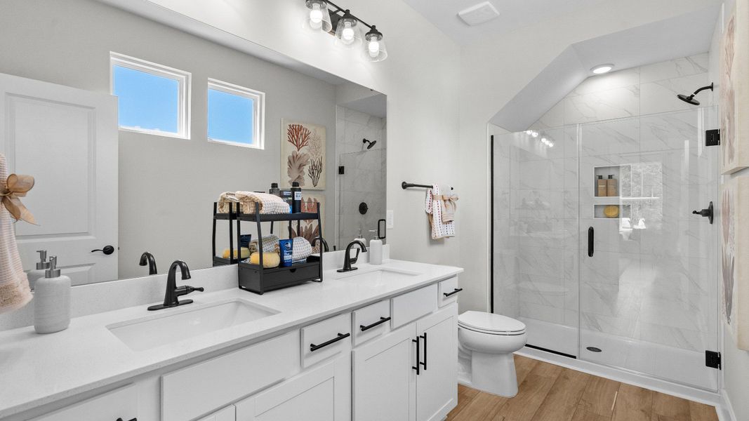 Primary bathroom in the Summit home plan with modern finishes and dual vanities.