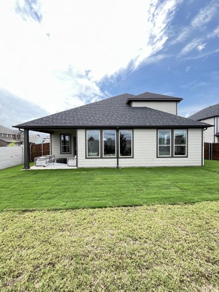 A modern home with large windows and a landscaped yard in Lakehaven by Trophy Signature Homes (Farmersville, TX).