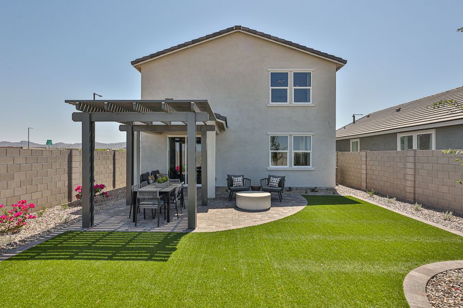 A house with a yard and a table and chairs.