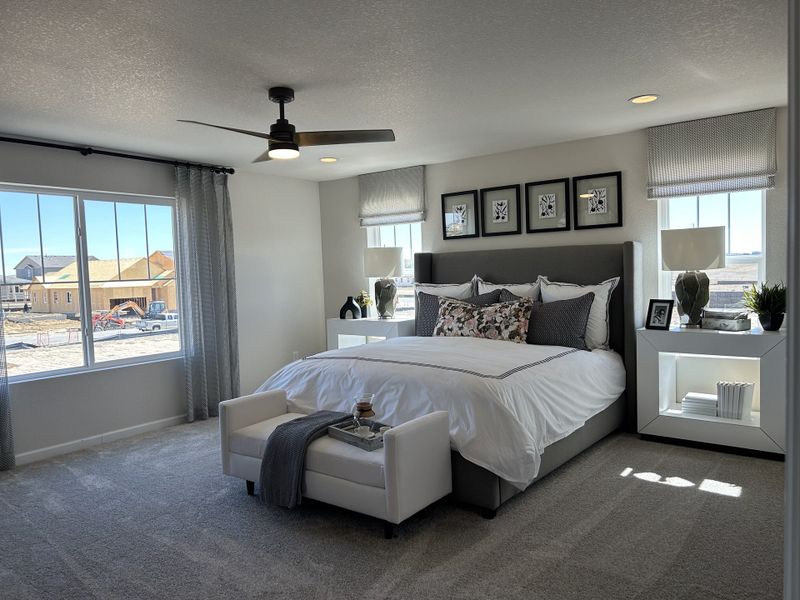 A spacious bedroom with modern decor, plush carpeting, and large windows offering abundant natural light.