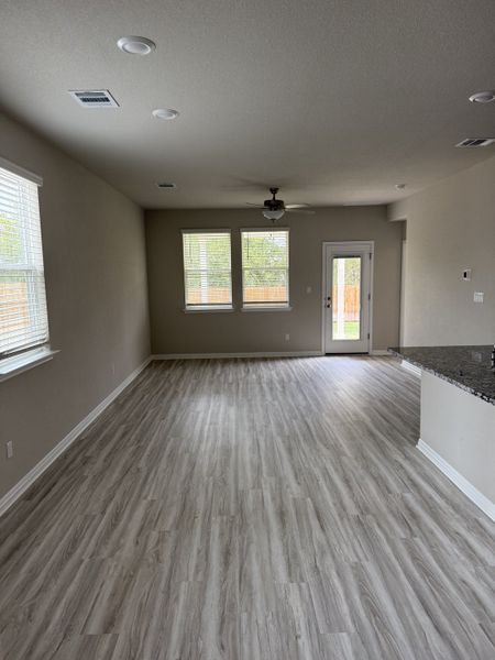 A cozy living room with beautiful light-colored flooring and ample natural light.