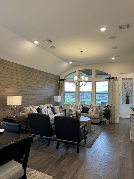 A cozy living room with a wood accent wall, plush seating, and large windows offering natural light and scenic views. A cozy living room with a wood accent wall, plush seating, and large windows offering natural light and scenic views.