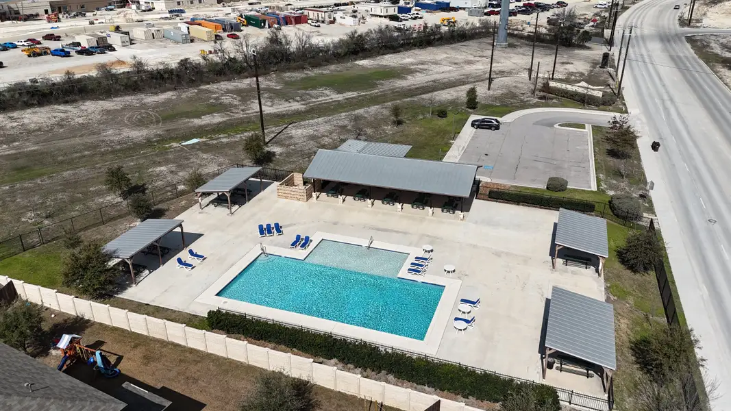 Community pool with shaded seating and play area in Hunters Ranch by First America Homes, San Antonio, TX.