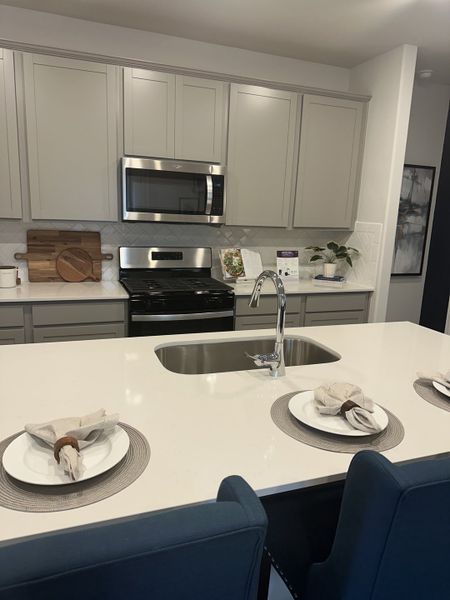 A modern kitchen with a sleek island, stainless steel appliances, and elegant cabinetry. A modern kitchen with a sleek island, stainless steel appliances, and elegant cabinetry.