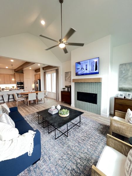 An inviting living space with a modern fireplace, cozy seating, and an open-concept kitchen and dining area.