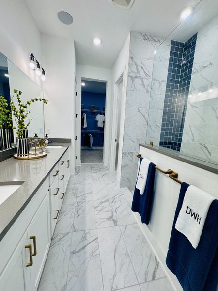 A modern bathroom with sleek cabinetry, marble flooring, and elegant lighting accents. A modern bathroom with sleek cabinetry, marble flooring, and elegant lighting accents.
