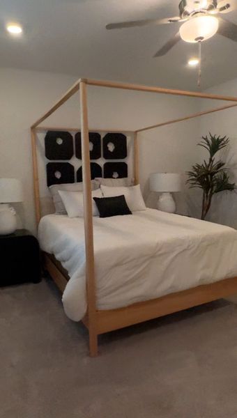 A cozy bedroom with a modern canopy bed, elegant black and white accents, and soft lighting. A cozy bedroom with a modern canopy bed, elegant black and white accents, and soft lighting.