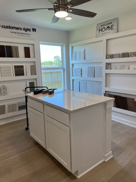 A sleek, modern interior design showroom with sample materials, bright lighting, and a central island for display. A sleek, modern interior design showroom with sample materials, bright lighting, and a central island for display.