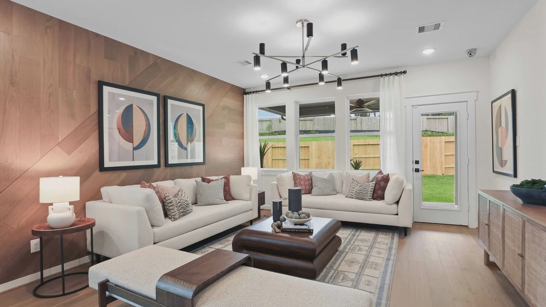 Experience elegance with a wood-paneled accent wall and chic lighting in Mostyn Springs' high-end living space. Experience elegance with a wood-paneled accent wall and chic lighting in Mostyn Springs' high-end living space.