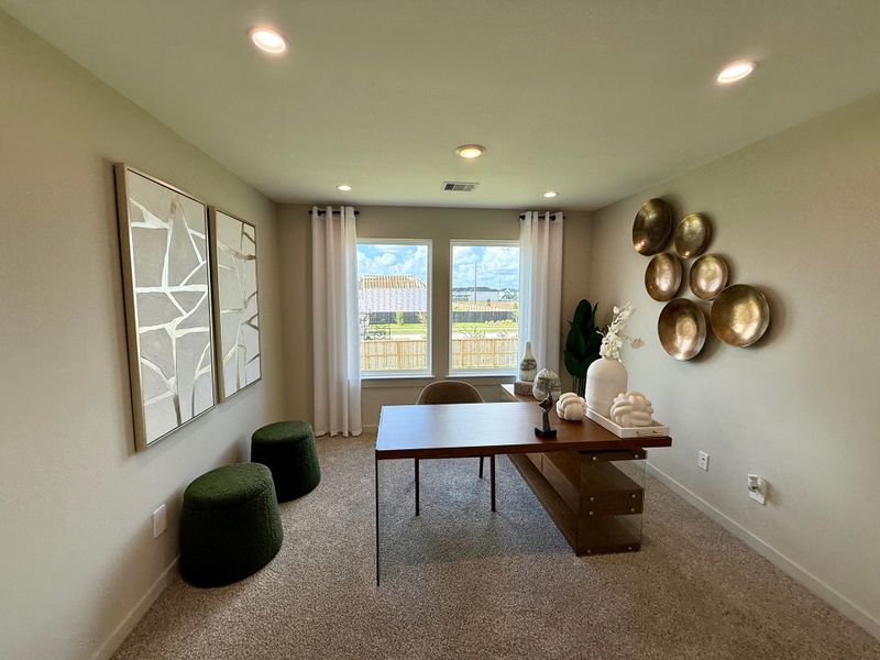 A modern home office with unique wall art, a sleek wooden desk, and large window for natural light.