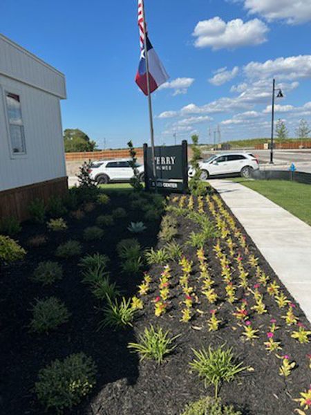 Beautifully landscaped entrance with vibrant plants in Hillstead 60' by Perry Homes, Lavon, TX.