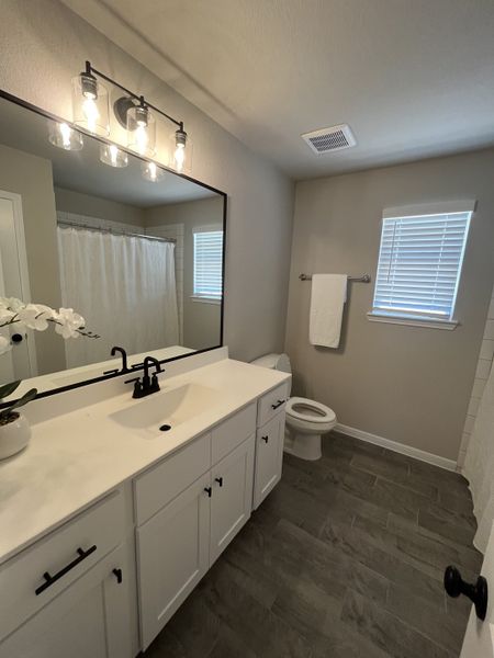 A modern bathroom featuring a sleek vanity, elegant lighting, and stylish flooring, creating a refreshing space. A modern bathroom featuring a sleek vanity, elegant lighting, and stylish flooring, creating a refreshing space.