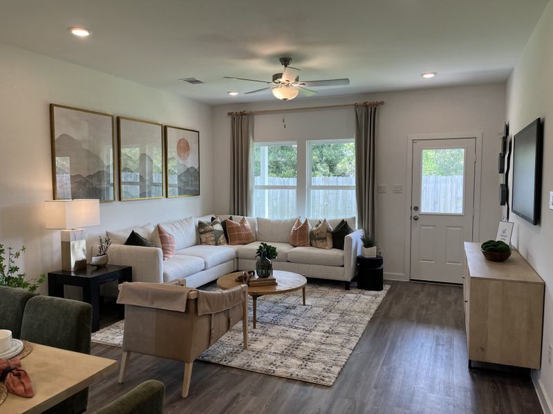 A cozy living room with a modern sectional sofa, large artwork, and warm lighting, creating an inviting atmosphere. A cozy living room with a modern sectional sofa, large artwork, and warm lighting, creating an inviting atmosphere.