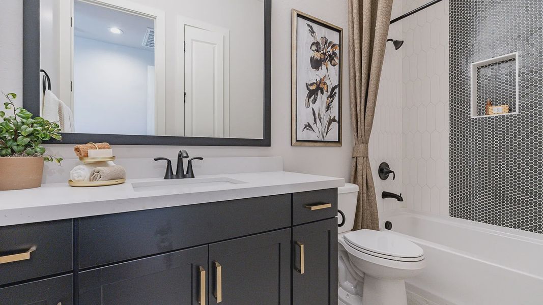 Sophisticated black vanity and hexagon wall tiles elevate this Windrose bathroom's elegance.