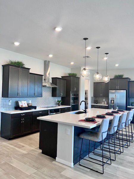 A modern kitchen featuring a spacious island, sleek black cabinets, and stylish pendant lighting. A modern kitchen featuring a spacious island, sleek black cabinets, and stylish pendant lighting.
