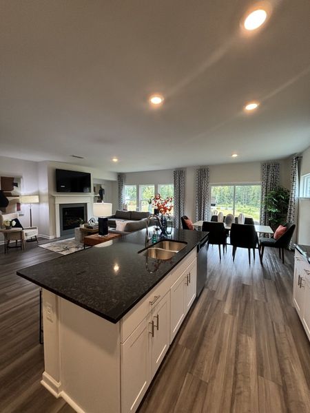 An open-concept living space with a granite island, cozy seating, and large windows offering abundant natural light.