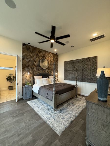 A cozy bedroom featuring a textured accent wall, elegant four-poster bed, and stylish decor with rich wood flooring. A cozy bedroom featuring a textured accent wall, elegant four-poster bed, and stylish decor with rich wood flooring.