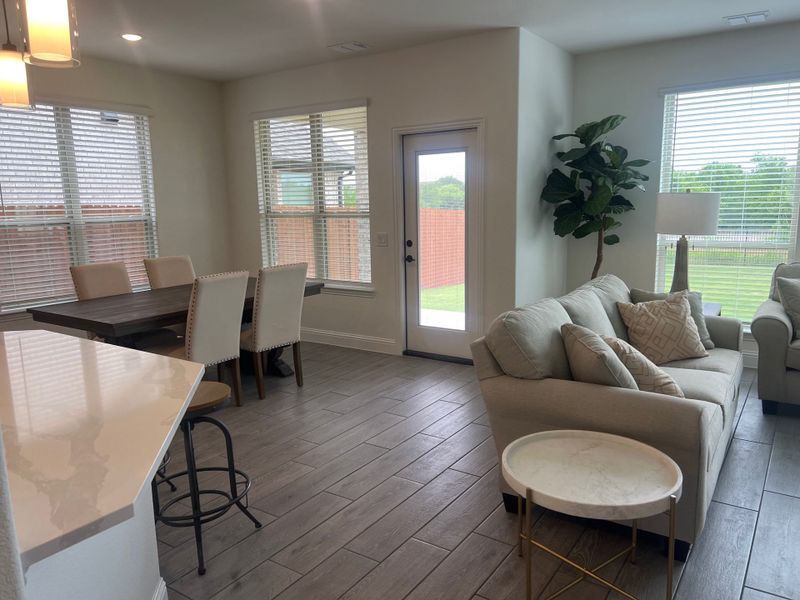 A cozy living area with light sofas, a round side table, and a dining space by large windows and patio door. A cozy living area with light sofas, a round side table, and a dining space by large windows and patio door.