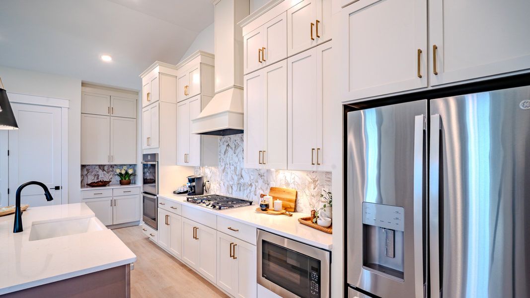 Kitchen with light cabinetry, quartz countertops, and tile backsplash