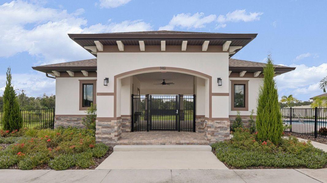 Grasslands West community clubhouse with modern architecture, landscaped entry, and resort-style amenities by DRB Homes.