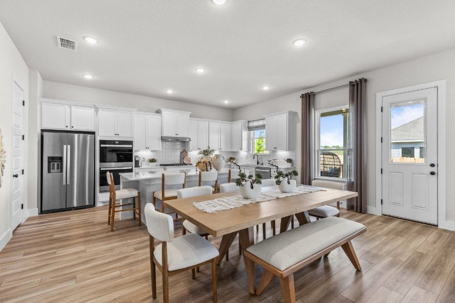 A kitchen with a dining table and chairs.