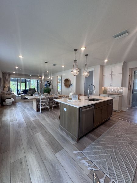 Modern open-concept kitchen and living area featuring elegant pendant lighting, sleek island, and chic dining space.