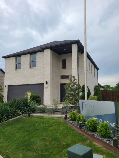 A modern two-story white brick home with sleek landscaping in Eastridge by Trophy Signature Homes (McKinney, TX). A modern two-story white brick home with sleek landscaping in Eastridge by Trophy Signature Homes (McKinney, TX).