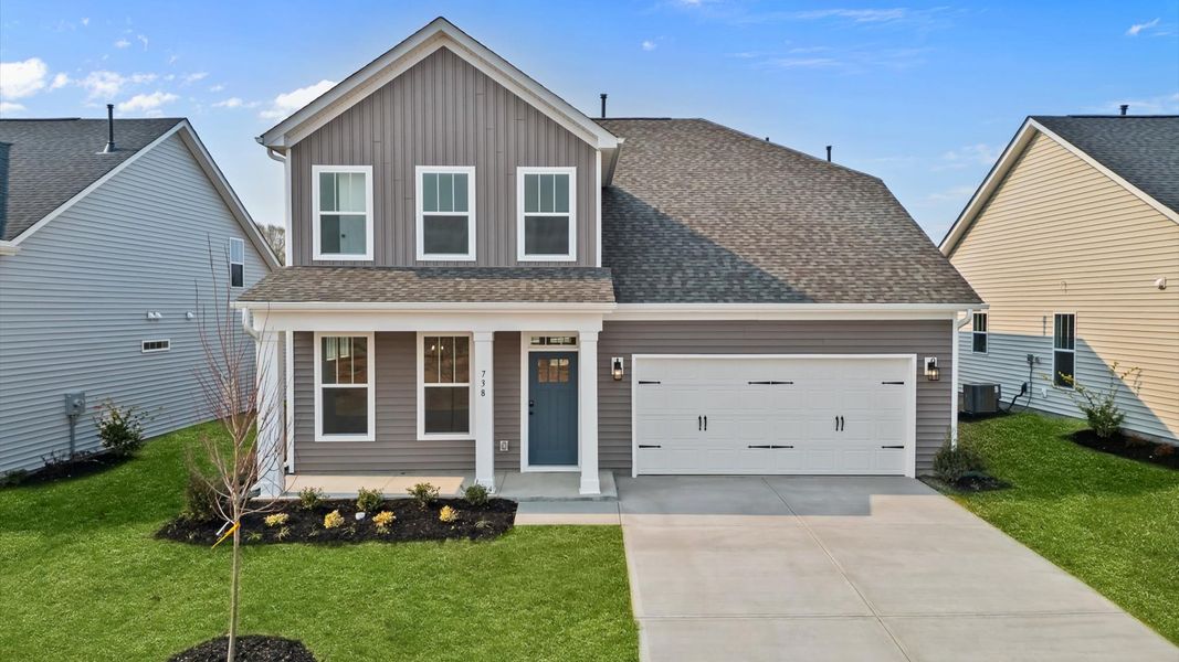 Augusta floorplan with neutral exterior and front porch at The Reserve at Livingston Park by DRB Homes in Easley, SC