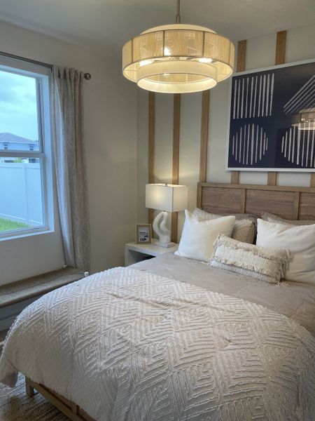 A cozy bedroom featuring textured bedding, soft lighting, and modern wall art for an inviting atmosphere.