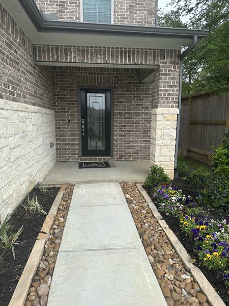 Charming entrance with brick and stone accents, vibrant flowers in Lakes at Black Oak by Century Communities (Magnolia, TX). Charming entrance with brick and stone accents, vibrant flowers in Lakes at Black Oak by Century Communities (Magnolia, TX).