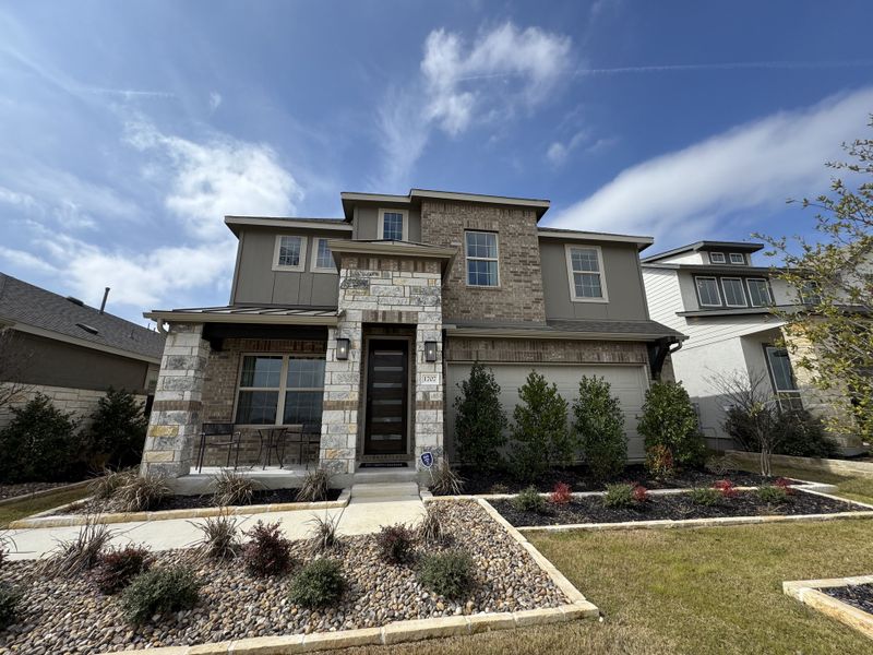 Elegant stone facade home with lush landscaping in Meyer Ranch by Brightland Homes (New Braunfels, TX). Elegant stone facade home with lush landscaping in Meyer Ranch by Brightland Homes (New Braunfels, TX).