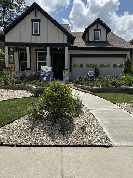 A charming home with elegant stone accents and lush landscaping in Colton 65' Homesites by David Weekley Homes (Todd Mission, TX).